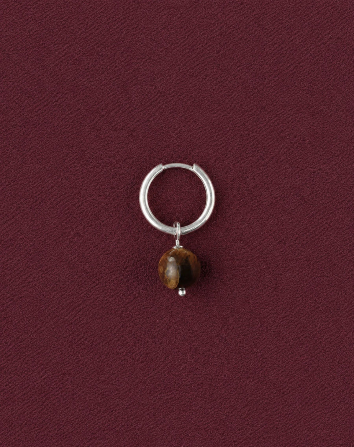 Créole argentée seule, boule de pierre brune veinée, sur tissu bordeaux