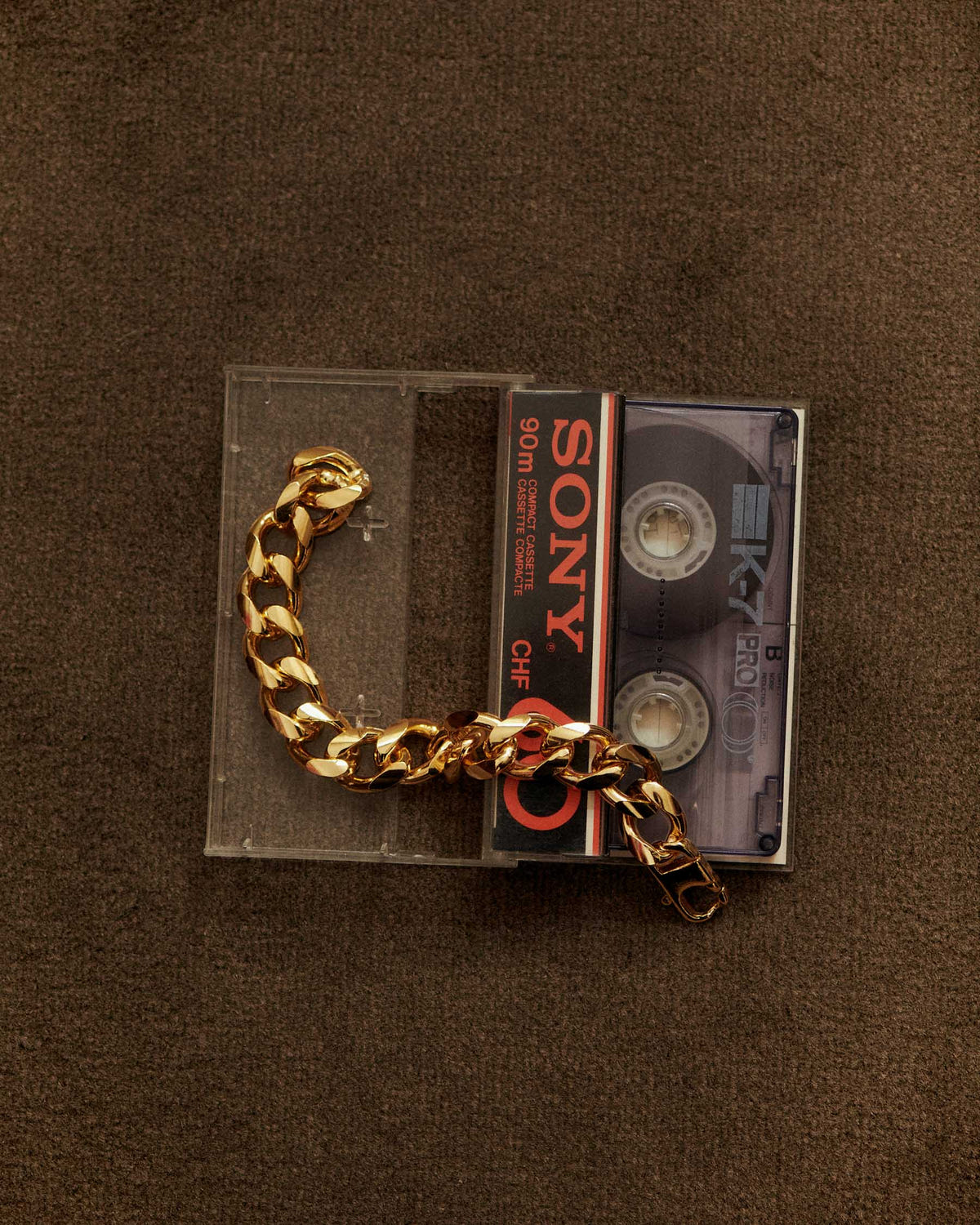 Gold version resting on a Sony cassette tape, brown velvet background