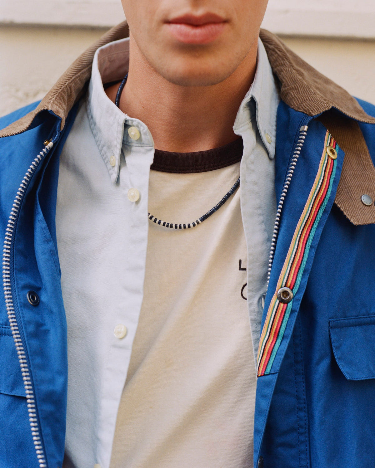 Lapis lazuli striped bead necklace over a striped tee, blue jacket with corduroy collar