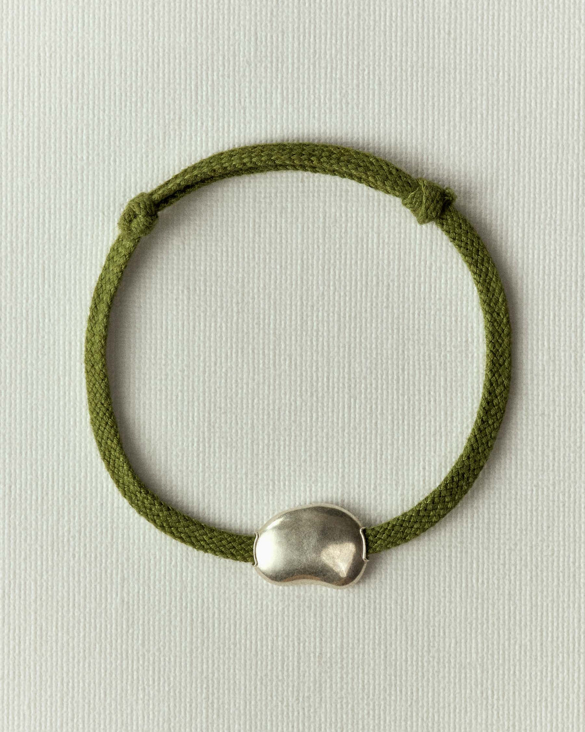 Le même en cordon vert olive, galet argenté centré et nœuds coulissants