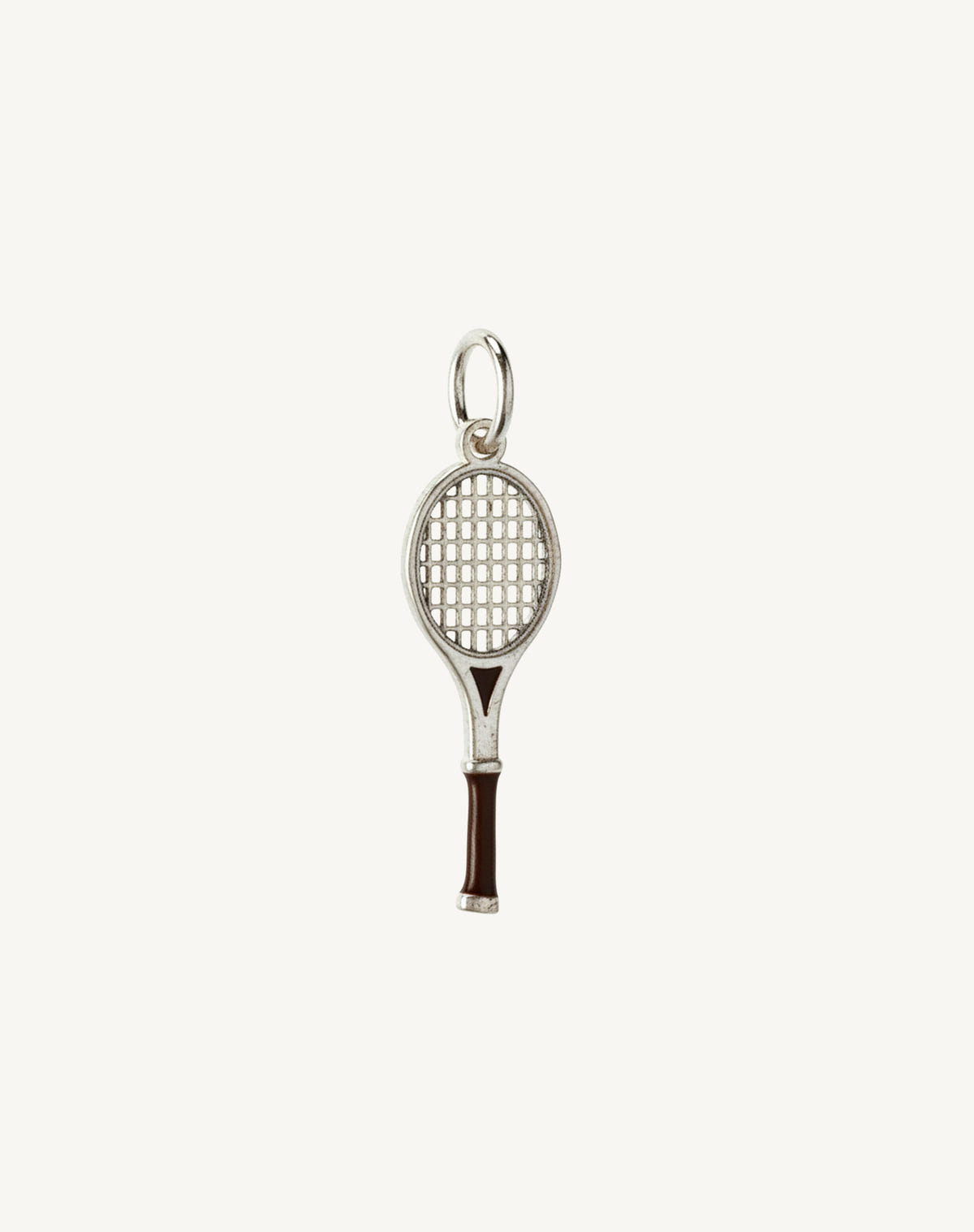 Silver tennis racket charm with a brown enamelled grip and open strings, cream background