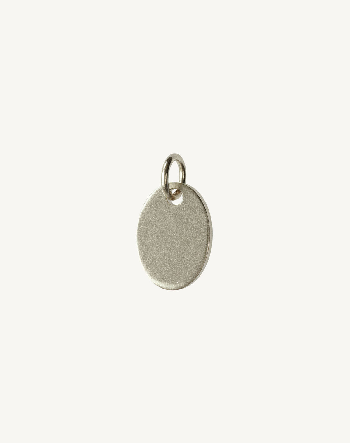Matte silver oval tag with an open jump ring, on an off-white background