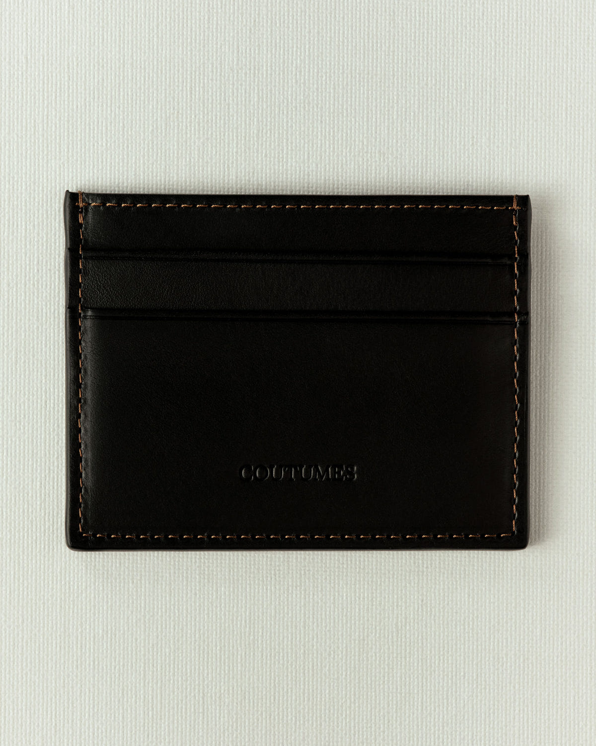 The same in black leather, tan stitching and a tonal embossed logo