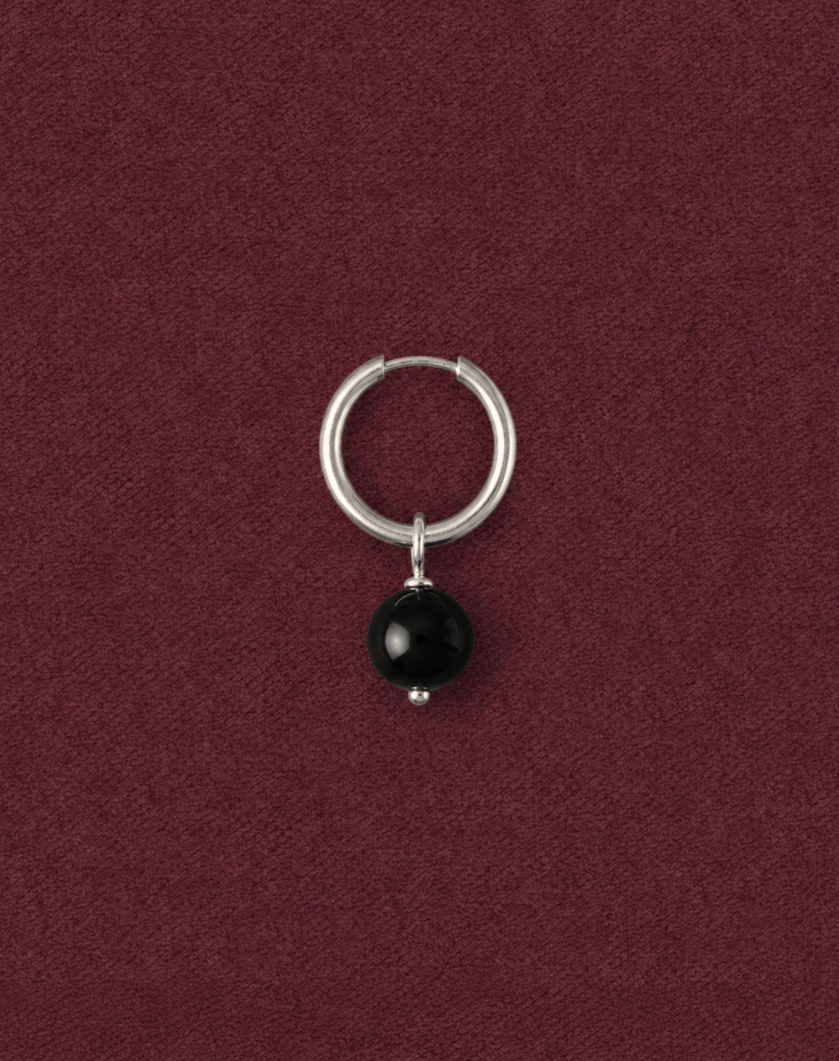 The same style with a glossy black bead, silver hoop on burgundy fabric
