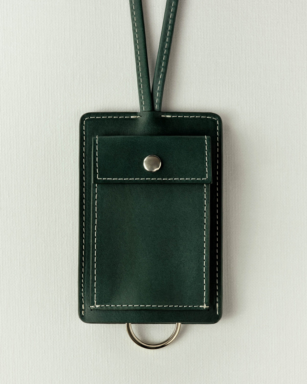 Same piece in dark green leather, off-white stitching and a silver snap