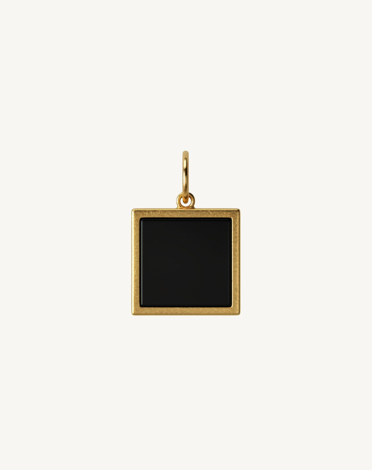 Pierre noire carrée sertie d'or brossé, bélière ronde, sur fond crème